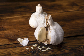 Two garlic cloves on a wooden board in soft side light