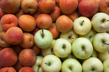 Ripe apricots and apples close up background
