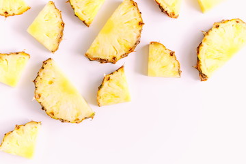 Pattern made of sliced pineapples. Slices of pineapple on a light pastel pink background. Summer concept. Flat lay, top view, copy space 