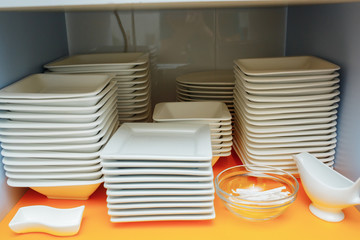 White plates on a shelf in a restaurant on a shelf