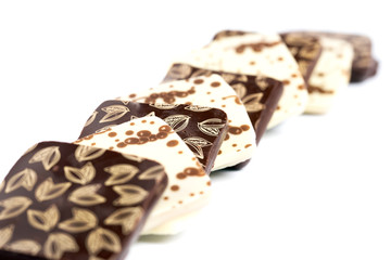 Chocolate candies of a square shape on a white background. Close-up.