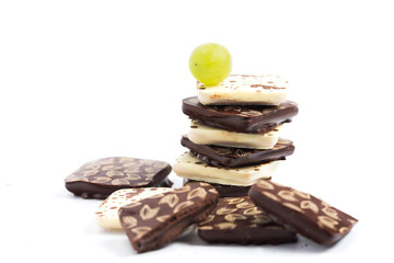 Chocolate candies on a white background with grapes.