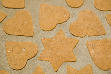 Homemade Gingerbread Cookies cut into Christmas star and heart shapes ready for baking