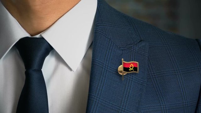 Businessman Walking Towards Camera With Country Flag Pin - Angola
