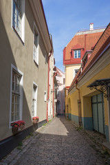 Fototapeta na wymiar Old buildings and narrow and empty street on Toompea Hill at the Old Town in Tallinn, Estonia, on a sunny day in the summer.