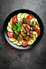 Salad with fresh and grilled vegetables and mushrooms. Vegetable salad with grilled champignons. Vegetable salad on plate