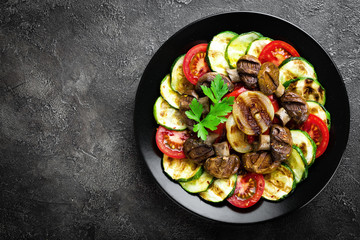 Salad with fresh and grilled vegetables and mushrooms. Vegetable salad with grilled champignons. Vegetable salad on plate