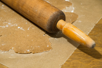 Preparing Christmas gingerbread cookies on wooden board. Gingerbread dough and rolling pin,...