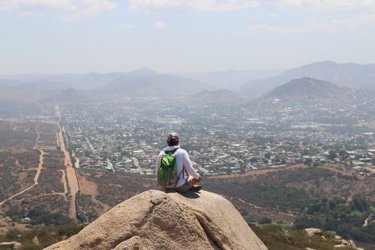 hiker sitting on rock with view