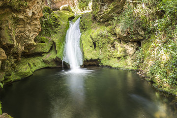 Fototapeta na wymiar Small waterfall falling into a pool of water.