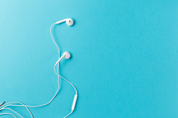 Flat lay concept: headphones on pastel backgrounds. white headphones on a blue background, top view, copyspace. Trendy colorful photo. Minimal style with colorful paper backdrop.
