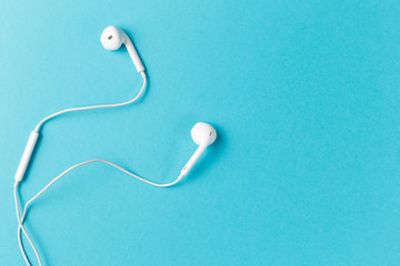 Flat lay concept: headphones on pastel backgrounds. white headphones on a blue background, top...