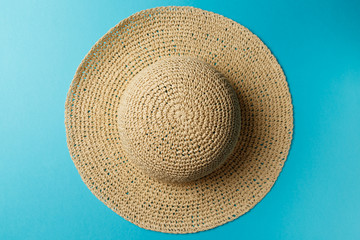 Fototapeta na wymiar braided hat on blue background. top view. summer concept