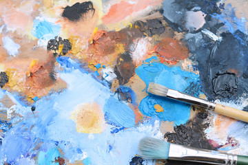 Colorful artist's palette with oil paint strokes.