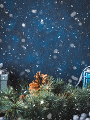 Christmas winter dark background with decorations on blue with green fir tree branches