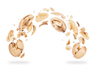 Walnuts crushed into pieces, frozen in the air on a white background