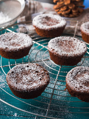 Chocolate chokecherry muffins with icing sugar. Winter christmas sweet food treat on dark green background