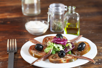 Plato de ensalada de tomates con anchoas. Dieta mediterránea