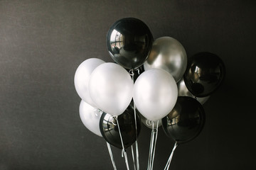 Black and white balloons on a dark black background. Celebration concept / White and black balloons...