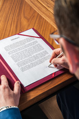 sign contract / the manager signs the official contract on the parties' agreement
