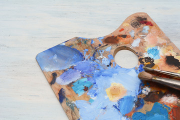 Artist's palette with colorful oil paint strokes and paintbrushes