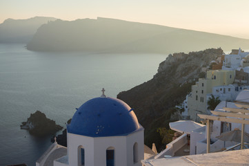 Fototapeta na wymiar Whitewashed Houses and Church on Cliffs with Sea View in Oia, Santorini, Cyclades, Greece