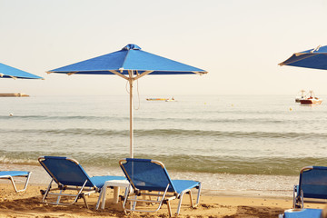 Beach in the resort in the summer. Umbrellas and chaise lounges on the sand of the summer beach.