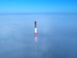 Brick chimney floating above the clouds, aerial view