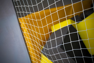 Gray and yellow cubes of foam rubber behind the grid in the gaming center