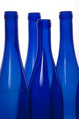 four blue bottlles on white background