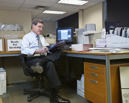 Business owner sitting at his desk while working on his computer inside an office in New York City, USA