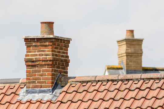 Brick chimney stack on modern contemporary house roof top