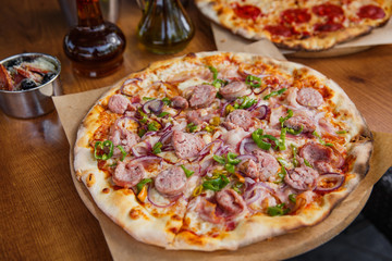 Hot delicious pizza with sausage, paprika and red onion.