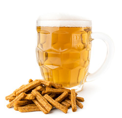 A glass of beer with foam and a bunch of crackers on a white, close-up.