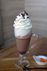 Chocolate milkshake drink with whipped cream on a glass.