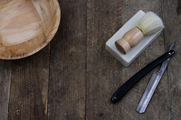 Razor, brush and soap on an old wooden table. Accessories for daily hygiene for men.