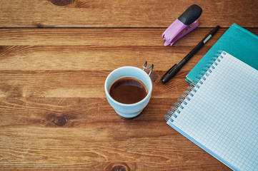 open notebook with pen and coffee on wooden table