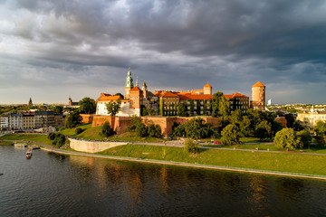 Krakow, Poland. Historic royal Wawel castle and cathedral.  Aerial view in sunset light with dark ...
