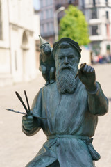 Sculpture of the painter and monkey at the street. The artist Bruegel is depicted at work. He writing the quarter (Marol) in which he lives.