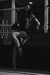Woman with boxing gloves on hands and dress, boxing in ring. Active girl fight. lady fight. monochrome