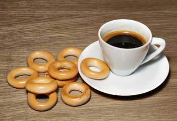 A cup of black coffee and dried biscuits on canvas