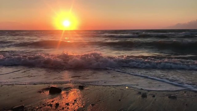 Beautiful Sunset over the ocean waves breaking on sandy beach Slow Motion footage