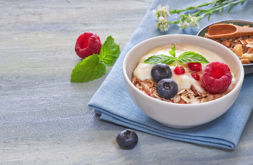 Yogurt with muesli and berries, healthy dessert on neutral background