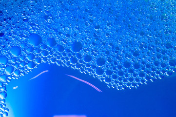 Naklejka na ściany i meble Bubbles on water surface with blue background
