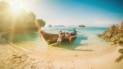 Two happy woman traveling by boat and enjoying the sun