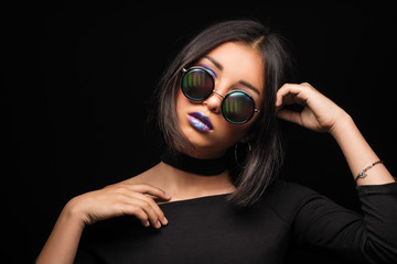 Portrait of cool crazy brunette fashionable girl in sunglasses, casual hairdo on black background....