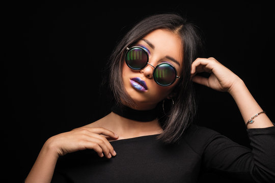 Portrait of cool crazy brunette fashionable girl in sunglasses, casual hairdo on black background. Woman like bitch with pretty makeup big lips