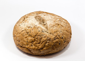 One round grain bread isolated on a white background.Whole fresh wheat and rye small bread with a lot of seeds: sunflower, pumpkin, sesame