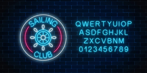 Glowing neon sign of sailing club with steering wheel in circle frames on dark brick wall background.