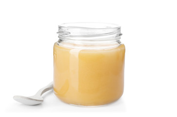 Jar with delicious honey and spoon on white background